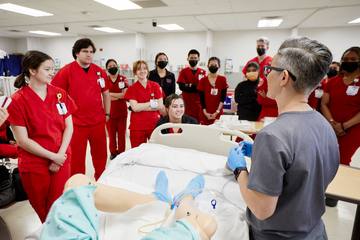 An instructor and students at a simulated patient