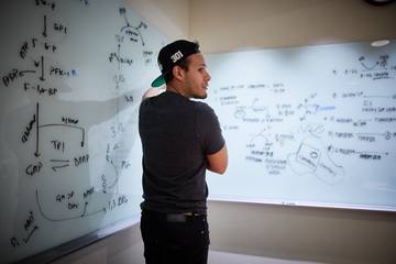 A student thinking at a whiteboard